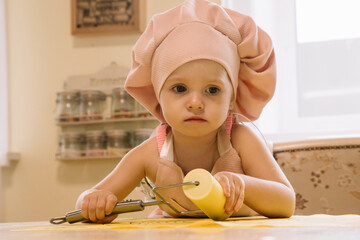 Little girl cooks at home in the kitchen