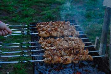Fry kebabs mounted on skewers. Below are hot charcoals.