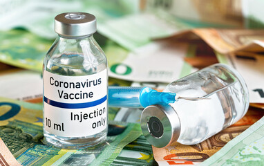 Coronavirus Covid-19 vaccine price / cost concept - glass vial with silver cap on pile of euro bank notes, syringe needle near, closeup detail (own sticker design with dummy data - not real product)