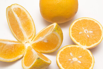 Orange fruit with orange slices and leaves isolated on white background.