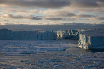 Antarctica landscape with ice and icebergs at sunset on a winter day