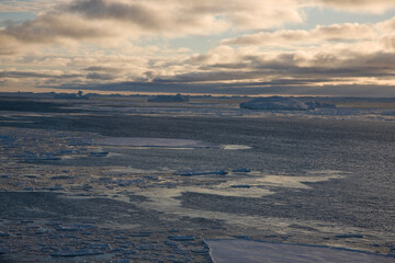 Antarctica landscape with ice and icebergs at sunset on a winter day