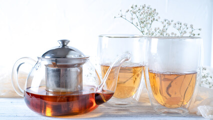 Bleak morning tea in double walled insulated glass mugs and glass teapot. Thermal glass tea cups. Bright morning tea