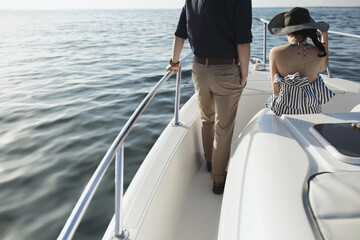 Man and Woman enjoying their time at the yacht in the middle of the blue sea