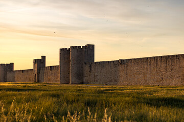 Vue au coucher du soleil sur les remparts et l'une des portes fortifi&eacute;es de la ville m&eacute;di&eacute;vale d'Aigues-Mortes (Occitanie, France)