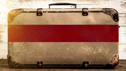 Vintage travel background - Close-up of old rustic travel suitcase with empty red banner with copy...