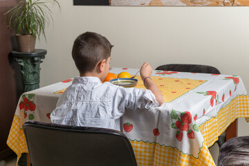 Niño de 8 años comiendo solo en casa