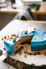 cut blue mousse cake on a wooden tray with nuts