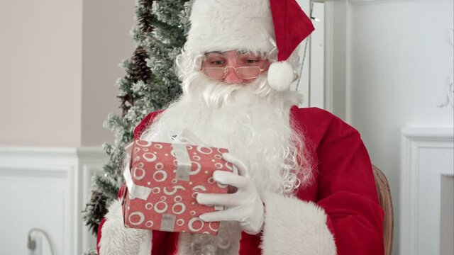 Santa Claus in his Christmas workshop signing presents for children
