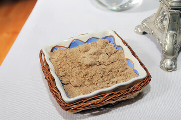 Arena, tierra en un tazón de porcelana y mimbre sobre una mesa colocada para una celebración.