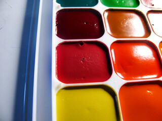new watercolor school paints in a plastic box on a white background