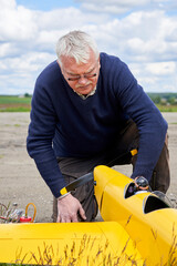 A man tests the motor before launching a radio-controlled aircraft.