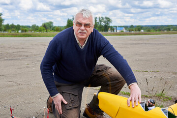 A man tests the motor before launching a radio-controlled aircraft.