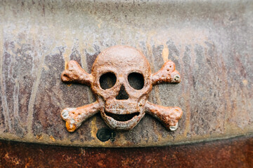 Close-up of a metallic rusty skull with bones made on an iron platform.