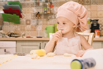 Little girl cooks at home in the kitchen