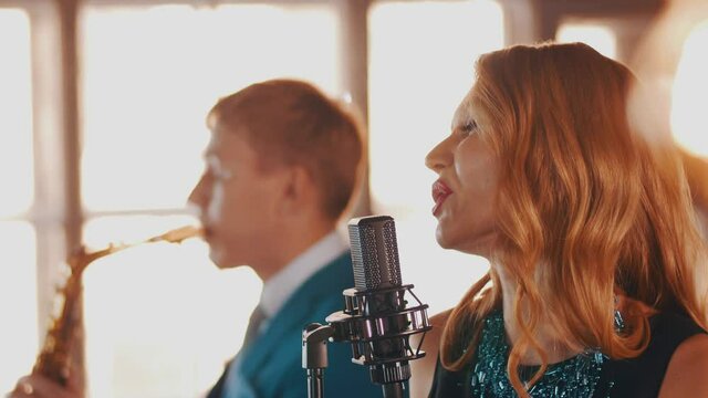 Jazz duet on stage restaurant. Vocalist. Saxophonist. Retro style. Spotlights Music band