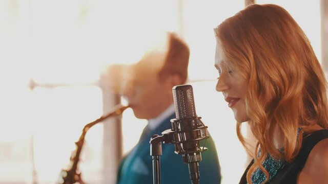 Jazz duet on stage restaurant. Vocalist. Saxophonist. Retro style. Spotlights Music band