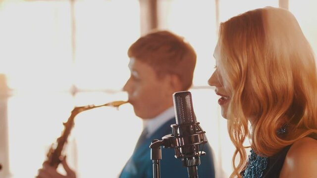 Jazz duet on stage restaurant. Vocalist. Saxophonist. Retro style. Spotlights Music band