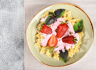 Pasta with strawberry cream and fresh strawberries and basil