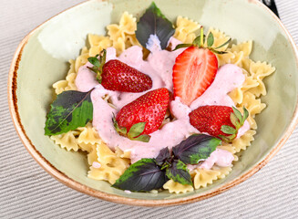 Pasta with strawberry cream and fresh strawberries and basil
