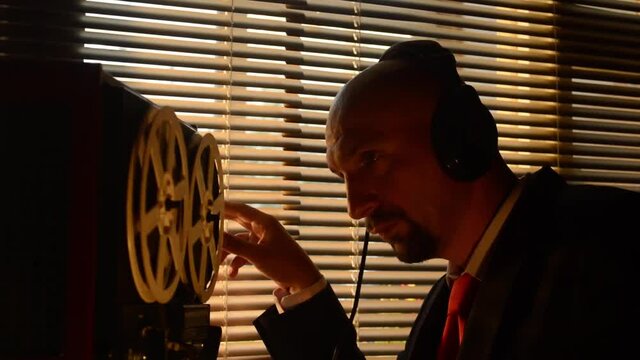 Secret special agent listens to the conversation, recording on a reel-to-reel tape