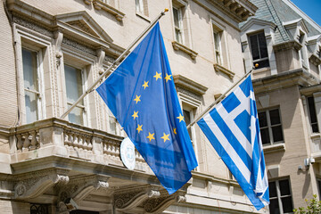 The EU and Greek flag fly in front of the Embassy of Greece in Washington, DC.