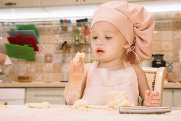 Little girl cooks at home in the kitchen