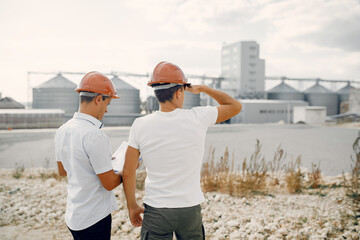 Engineers near the factory. Mtn in a helmet. Inspector looks at the building.