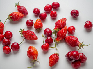 Fototapeta na wymiar Bright mix of red cherries and strawberries