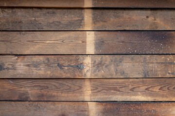 old shabby wooden plank fence with knots, crevices and dark spots. rough surface texture
