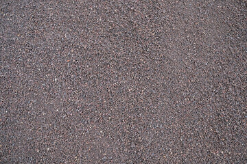 Fine coarse gravel material, flat empty surface with texture and pattern of ground mineral stones.