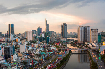 Fototapeta na wymiar Aerial cityscape of Ho Chi Minh City in early evening with Saigon river, residential area and business skyscrapers