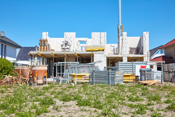 Baustelle eines Einfamilienhauses auf der der Rohbau errichtet wird.
