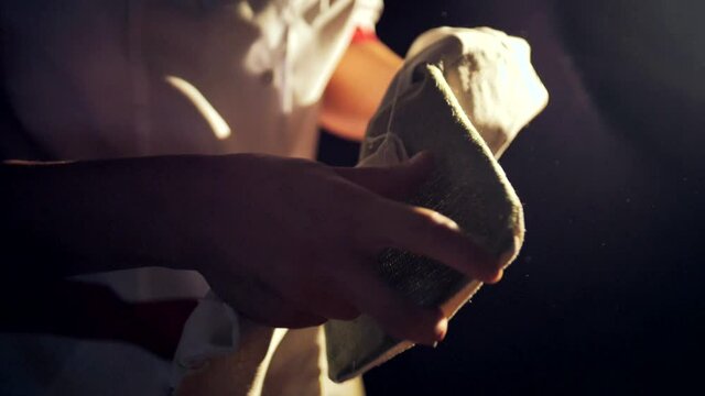 A close-up of the cook shakes off his mittens with flour.  Baker at the beginning of the working day. - Powered by Adobe