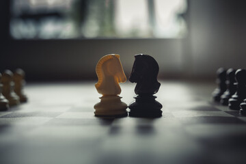 Black And White Knight Duel. Chess Pieces On Chessboard. Corporate Takeover.