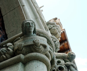 A sculpture of a human bust, detail facade of an old Medieval building.