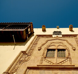 Obraz premium Decorative facade of a rich house with fine details carved in sandstone. A window and a balcony in Mexican Spanish architecture.