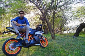 Fototapeta na wymiar Stylish male model with motorcycle or sports bike