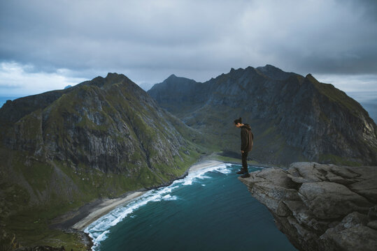 Man standing on cliff at Ryten mountain in Lofoten Islands