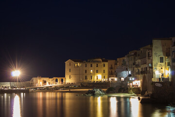 Fototapeta na wymiar Cefalu at night, Sicily, Italy. Seascape, cityscape. View on harbor and old houses. September 2019
