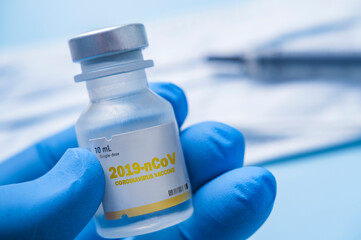 Close-up of gloved hand holding vial of Coronavirus vaccine