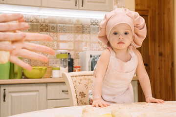 Little girl cooks at home in the kitchen