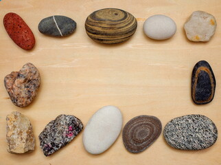Frame made of large stones on a wooden background