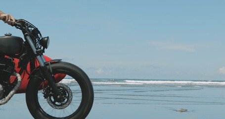 Fototapeta na wymiar Motorcyclist driving his motorbike on the beach