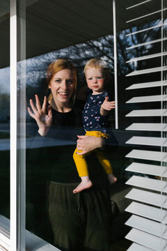 Mother And Daughter (2-3) Waving Through Window