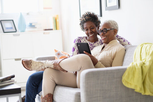 Smiling women using tablet in living room