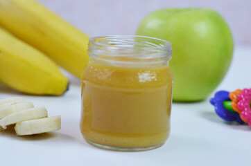 Baby food, banana mashed potatoes and bananas on a white background it is isolated.