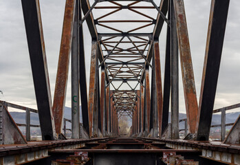 Low angle close-up of an abandoned steel railway bridge after rain
