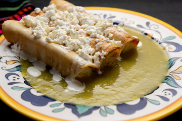Mexican drowned flautas with green sauce also called 