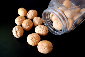 Walnuts spilled from a can on a black table